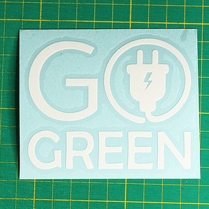 May include: White vinyl sticker with the text "GO GREEN" and a stylised image of an electrical plug with a lightning bolt inside a circle.