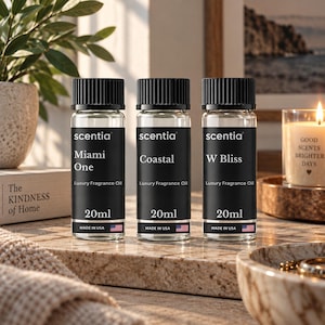 Puede incluir: Tres frascos de vidrio transparente de aceite de fragancia de lujo Scentia, cada uno con tapa negra y etiqueta negra. Las etiquetas tienen impreso el texto Scentia, los nombres Miami One, Coastal y W Bliss, 20ml y Made in USA con una bandera.