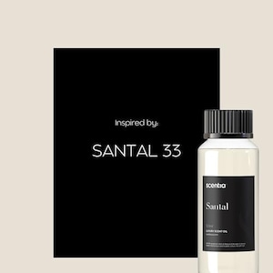 Op de afbeelding: Een zwart-wit afbeelding met de tekst "Inspired by: SANTAL 33" op een zwarte achtergrond. Op de voorgrond staat een doorzichtige glazen fles met een zwarte dop en een etiket met de tekst "sentia Santal 100ml LUXURY SCENT OIL".
