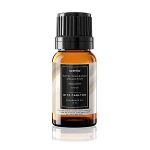 May include: A brown glass bottle of fragrance oil with a black cap. The label reads "scentia HOTEL FRAGRANCE COLLECTION" and "RITZ CARLTON". The bottle contains 10 mL of oil.