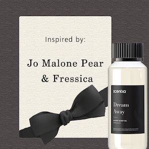 May include: A clear glass bottle with a black cap and label that reads "scentia Dream Away 120ml LUXURY SCENT OIL". The bottle is inspired by Jo Malone Pear & Fressica.