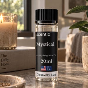 May include: A clear glass bottle of Scentia Mystical luxury fragrance oil with a black cap. The black label features white text reading Scentia, Mystical, Luxury Fragrance Oil, 20ml, Discovery Size, and a small American flag icon labeled Made in USA.