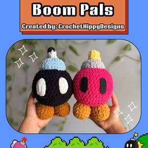 Könnte beinhalten: Zwei gehäkelte Boom Pals, einer schwarz und einer rosa, mit weißen Augen und braunen Füßen. Das Bild enthält den Text "Free Pattern Boom Pals" und "Created by: CrochetHippyDesigns". Der Hintergrund ist blau mit pixeligen Grafiken.