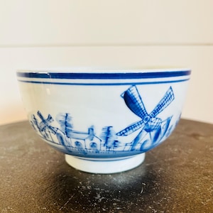 May include: A white ceramic mug with a black handle and the text "But First, Coffee" in a black, handwritten-style font. The mug is on a white surface.