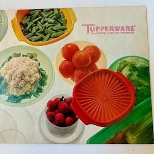 Könnte beinhalten: Eine Vintage-Tupperware-Werbung mit dem Text Tupperware An Airtight Case For Freshness. Das Bild zeigt verschiedene Kunststoff-Vorratsbehälter in Orange, Gelb und Grün, gefüllt mit grünen Bohnen, Blumenkohl, Tomaten und Erdbeeren.
