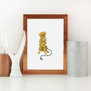 May include: A framed illustration of a golden retriever dog tangled in Christmas lights. The dog is sitting and looking at the viewer. The frame is copper colored.