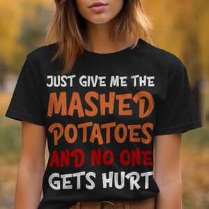 May include: Black t-shirt with the text "Just give me the mashed potatoes and no one gets hurt" in white and orange lettering.