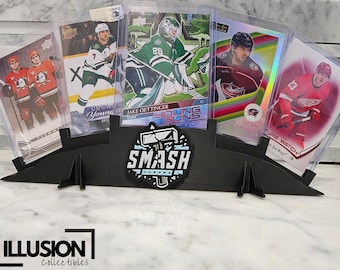 May include: A black card holder with a Smash Breaks logo. The holder has five slots for displaying trading cards. The cards are hockey cards featuring players from different teams.