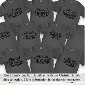 May include: A collection of gray t-shirts with the word "Blessed" and various family titles in black script. Titles include "Girlfriend," "Aunt," "Cousin," "Fianc&eacute;," "Mom," "Grandmother," "Stepmom," "Sister," and "Mama."