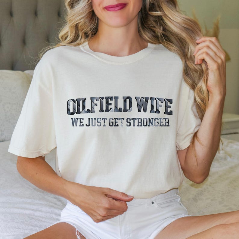 May include: A white ceramic mug with a black handle and the text "But First, Coffee" in a bold, black font. The mug is set against a blurred background, suggesting a cozy setting.