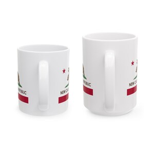 May include: Two white ceramic mugs with the New California Republic flag design. The design includes a bear, a red stripe, a red star, and the words "NEW CAL REPUBLIC". The mugs have white handles.