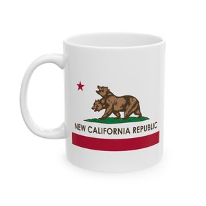 May include: White ceramic mug featuring the New California Republic flag design. The design includes two brown bears, a red star, and a red stripe, with the text "NEW CALIFORNIA REPUBLIC".