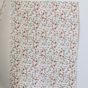 May include: A white background with a repeating pattern of green leaves and red berries. The pattern is reminiscent of a traditional Christmas design.