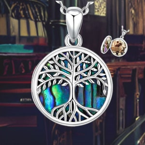 May include: A silver tree of life pendant necklace with a round abalone shell inlay. The pendant is open on the back and can be used as a locket. The necklace is on a silver chain.
