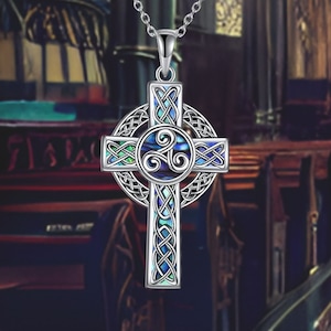 May include: A silver Celtic cross pendant with a blue and green abalone shell inlay. The cross is decorated with intricate knotwork and a trinity knot in the center.