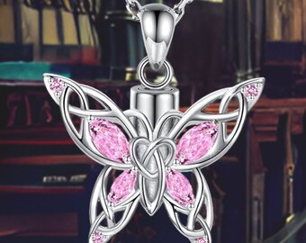 May include: A silver butterfly cremation necklace with pink crystals. The pendant has a small urn for holding ashes or other mementos.