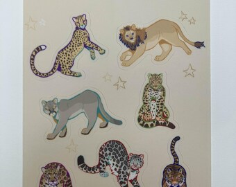 Puede incluir: Una hoja de pegatinas con ilustraciones de grandes felinos, como un guepardo, un león, un puma, un leopardo y un tigre. El texto "World Wide Big Cats" está impreso en la parte superior, con estrellas. Las pegatinas son de varios colores.
