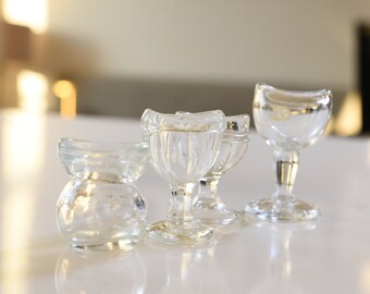 Quatre verres de lavage oculaire transparents antiques, tous avec des marques de fabricant (John Bull, Glasco, etc.)