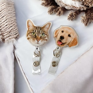 May include: Two clear plastic badge holders with retractable reels. One holder features a photo of a tabby cat, the other a golden retriever puppy.