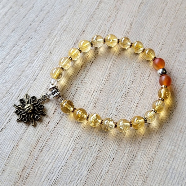 Bracelet citrine soleil fait main avec breloque soleil imitation bronze et cornaline givrée avec espaceurs bi-cônes en alliage métallique.