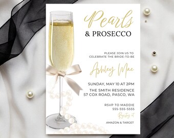 May include: A white invitation with gold text for a bridal shower. The invitation features a glass of champagne with a pearl necklace and a bow. The text reads "Pearls & Prosecco" and "Please join us to celebrate the bride-to-be Ashley Mae". The invitation also includes the date, time, location, RSVP information, and registry information.