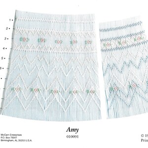 May include: A blue and white embroidery pattern with a floral design. The pattern is called "Amy" and the number 010091 is printed below the name. The text "1989 Ellen McCarn Printed in U.S.A." is printed at the bottom of the image.