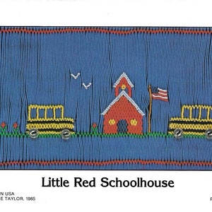 May include: A cross-stitch pattern featuring a red schoolhouse with a white bell tower, two yellow school buses, and a small American flag. The pattern is on a blue background with green grass and red flowers.