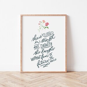 May include: A white printable art print with a floral design and the text "She is clothed in strength and dignity. She laughs without fear of the future. Prov 31:25"