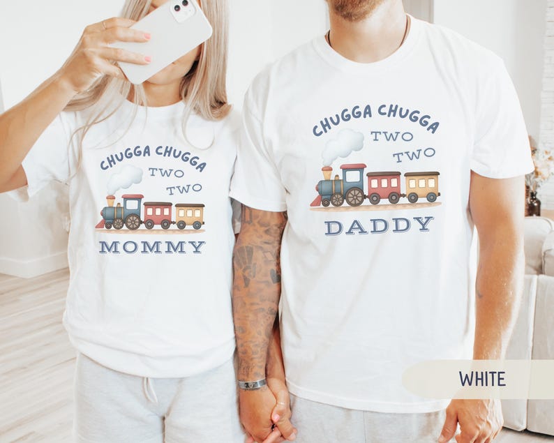 May include: White t-shirts with a train graphic and the text "Chugga Chugga Two Two." One shirt says "Mommy" and the other says "Daddy." The train is blue, red, and yellow.