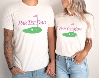 May include: White t-shirts with a golf-themed design. The text on the shirts reads "Par Tee Dad" and "Par Tee Mom".