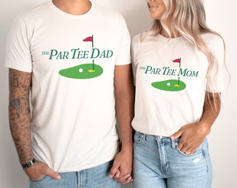 May include: Two white t-shirts with a golf-themed design. The text on the shirts reads "The Par Tee Dad" and "The Par Tee Mom".