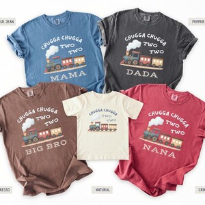 May include: Five short-sleeved t-shirts in various colors, including blue, gray, brown, cream, and red. Each shirt features a train graphic with the text "Chugga Chugga Two Two" and a family member's title: Mama, Dada, Big Bro, or Nana.