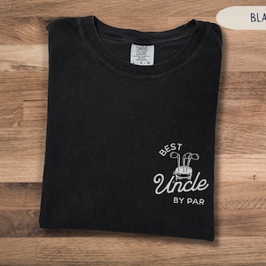 May include: Black t-shirt with a white graphic that says "Best Uncle By Par" with a golf club design.