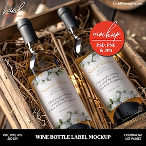 Puede incluir: Dos botellas de vino con etiquetas blancas en una caja de madera. Las etiquetas presentan flores blancas y un texto que dice "Sarah & Michael" y "June 15, 2025 Lakeview Vineyard". El texto continúa con "Gracias por celebrar nuestro día especial con nosotros. ¡Salud por el amor y la felicidad! Chardonnay, 2024".