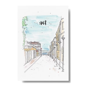 May include: A watercolour illustration of a street scene in Split, Croatia. The artwork depicts buildings lining a cobbled street, with the word "Split" written in black script. The sky is light blue, and the style is a sketch.
