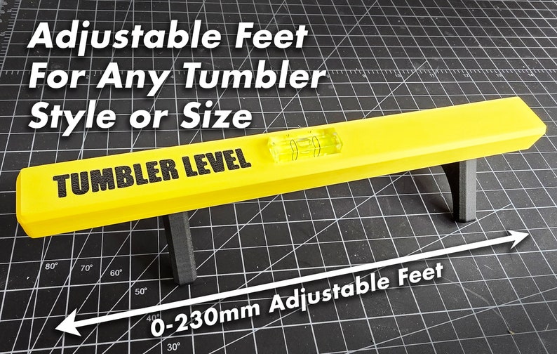 K&ouml;nnte beinhalten: Eine gelbe Wasserwaage mit verstellbaren F&uuml;&szlig;en, beschriftet mit "Tumbler Level". Die F&uuml;&szlig;e sind von 0 bis 230 mm verstellbar.