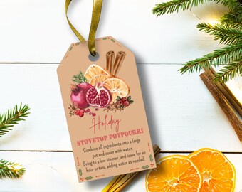 May include: A tan gift tag featuring a watercolour illustration of a pomegranate, orange slices, and cinnamon sticks. The tag reads "Holiday STOVETOP POTPOURRI" with instructions for making potpourri. A gold ribbon is attached.