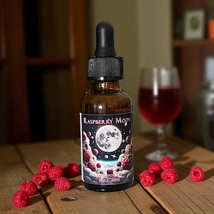 Puede incluir: Una botella de vidrio marrón con tapa cuentagotas negra, etiquetada como "Raspberry Moon". La etiqueta presenta una luna llena, frambuesas y estrellas. La botella contiene 30 ml de líquido. Hay frambuesas frescas esparcidas.