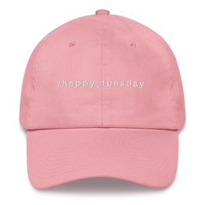 Puede incluir: Una gorra de béisbol rosa con el texto "/happy_tuesday" bordado en blanco en la parte delantera.