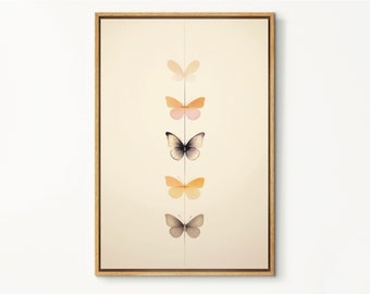 Peut inclure: Une impression encadrée avec un arrangement vertical de cinq papillons dans différentes nuances d'orange, de rose et de gris sur un fond crème.