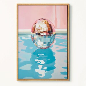 May include: A silver disco ball floating in a blue pool with a pink wall in the background.