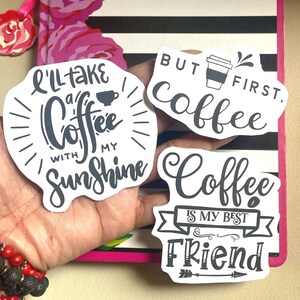 Puede incluir: Tres pegatinas blancas con texto negro sobre caf&eacute;. Una dice "I'll take a coffee with my sunshine", otra dice "But first, coffee", y la &uacute;ltima dice "Coffee is my best friend".