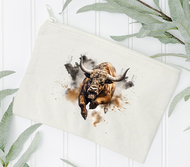 May include: A white canvas zippered pouch with a brown bull charging through a cloud of dust. The bull has a fierce expression and is depicted in a watercolor style.