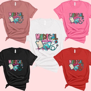 May include: Five different colored t-shirts with the text "MEDICAL Records" in colorful letters and a graphic of a stethoscope, syringe, and medical chart. The shirts are pink, red, black, white, and heather gray.