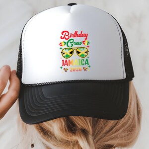 A person wearing a white and black baseball cap with a colorful graphic and text printed on it.