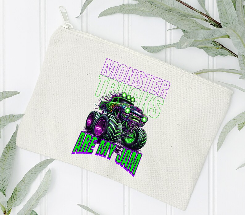 May include: A white canvas zippered pouch with a green and purple monster truck graphic and the text "Monster Trucks Are My Jam".