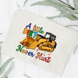 May include: A white canvas zippered pouch with a colorful graphic of a yellow excavator with the text "A little dirt never hurt".