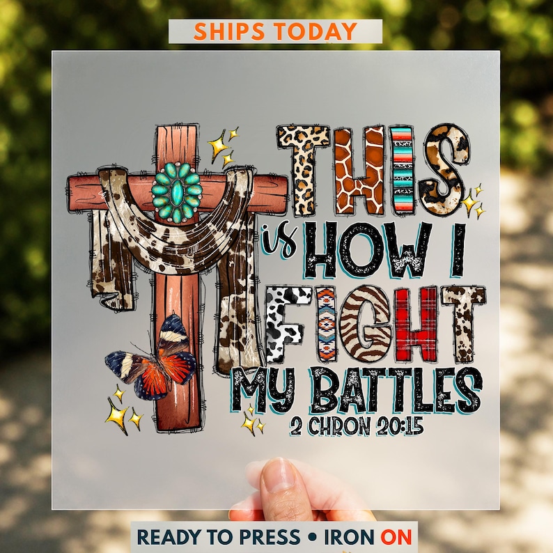 The image is a hand holding a printed piece of paper with a colorful and artistic design featuring a cross, butterflies, and various text elements.