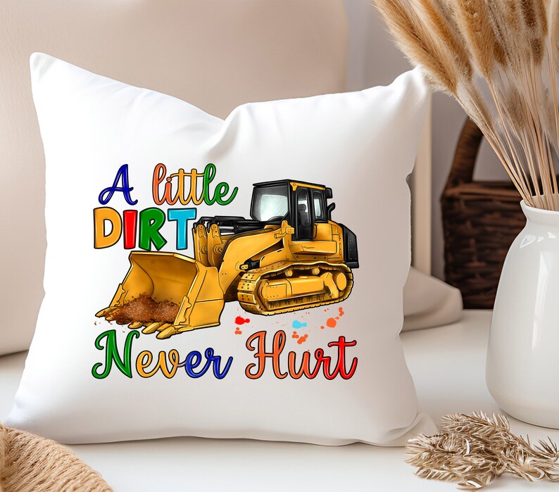 May include: White pillow with a yellow bulldozer graphic and the text "A little dirt never hurt" in rainbow colors.