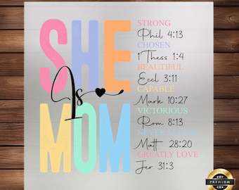 May include: A colorful metal sign with the words "She is Mom" in large letters. The sign also includes a list of Bible verses with words describing a mother, such as strong, chosen, beautiful, capable, victorious, and greatly loved.